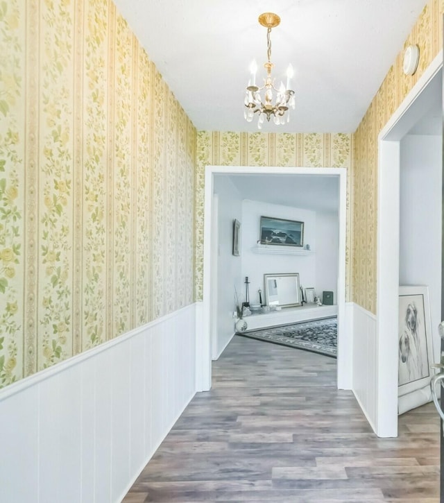 4308 Red Oak Dr, Nacogdoches, TX 75965 - hallway featuring wallpapered walls, wood finished floors, wainscoting, and a notable chandelier