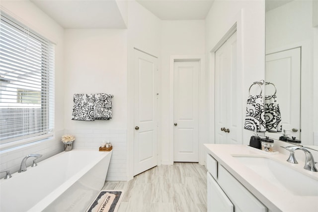 full bathroom featuring vanity and a freestanding tub
