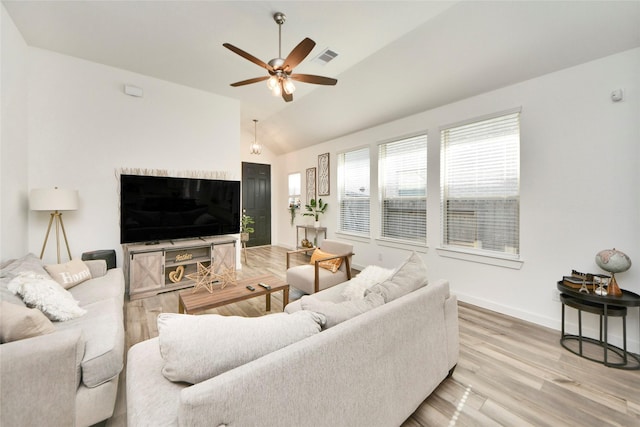 living room featuring wood finished floors, visible vents, vaulted ceiling, ceiling fan, and baseboards