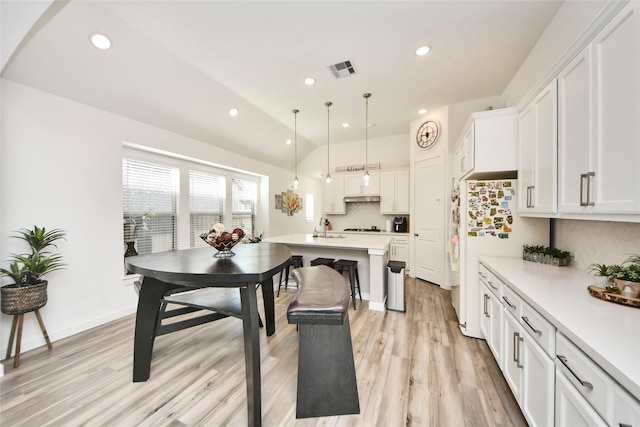 kitchen with freestanding refrigerator, tasteful backsplash, visible vents, light countertops, and white cabinets