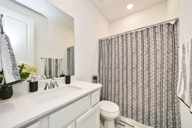 bathroom with toilet, vanity, and recessed lighting
