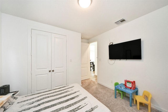 bedroom with carpet floors, baseboards, visible vents, and a closet
