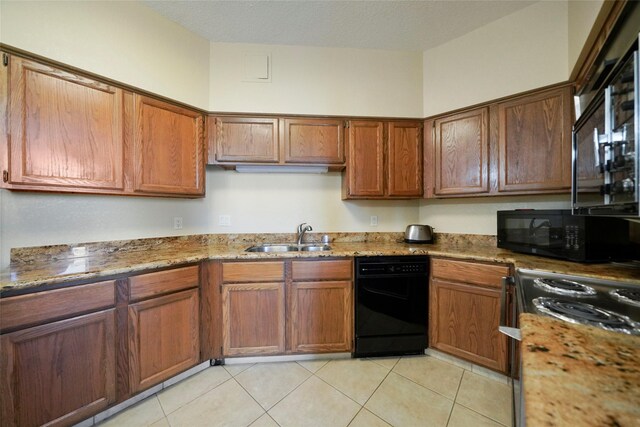 kitchen featuring a sink, black appliances, light stone counters, and light tile patterned floors