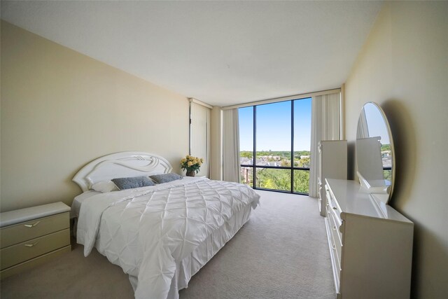bedroom featuring light carpet and a wall of windows