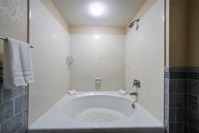 full bath featuring a textured ceiling and shower / bathtub combination