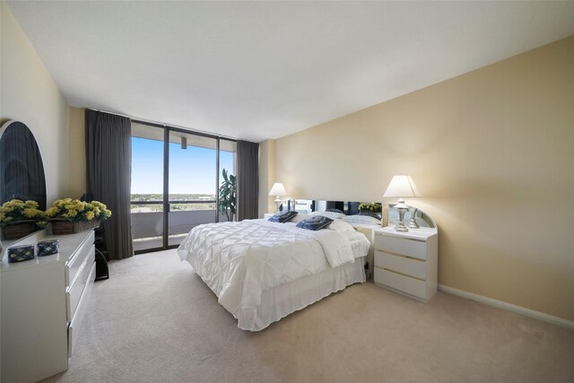 bedroom featuring light carpet, access to outside, floor to ceiling windows, and baseboards