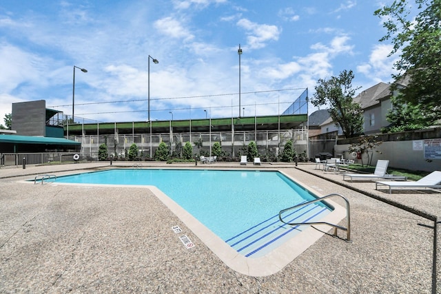 community pool featuring fence and a patio area