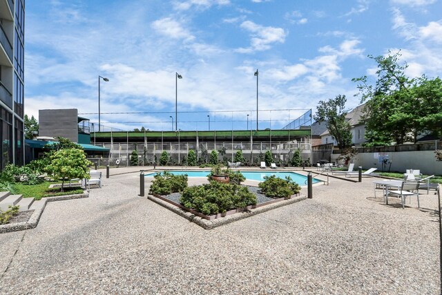 community pool with fence and a patio area