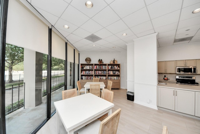 dining space with healthy amount of natural light, a paneled ceiling, and recessed lighting