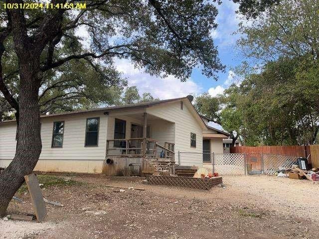 rear view of property featuring a porch and fence