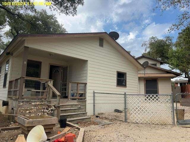 view of side of home featuring a porch and fence