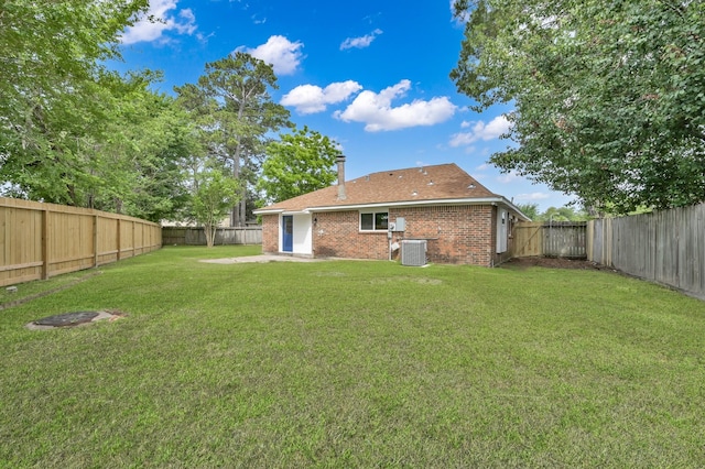 22603 Pebworth Pl, Spring, TX 77373 - back of house featuring central AC unit, brick siding, and a chimney