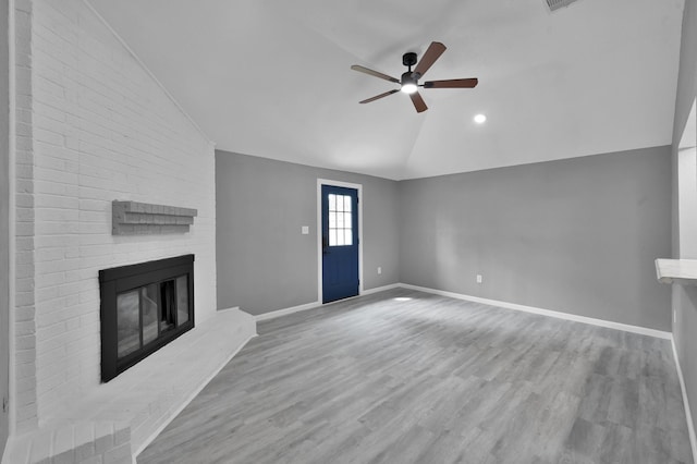 22603 Pebworth Pl, Spring, TX 77373 - unfurnished living room with vaulted ceiling, a ceiling fan, a fireplace, wood finished floors, and baseboards