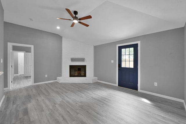 22603 Pebworth Pl, Spring, TX 77373 - unfurnished living room featuring vaulted ceiling, ceiling fan, wood finished floors, baseboards, and a brick fireplace