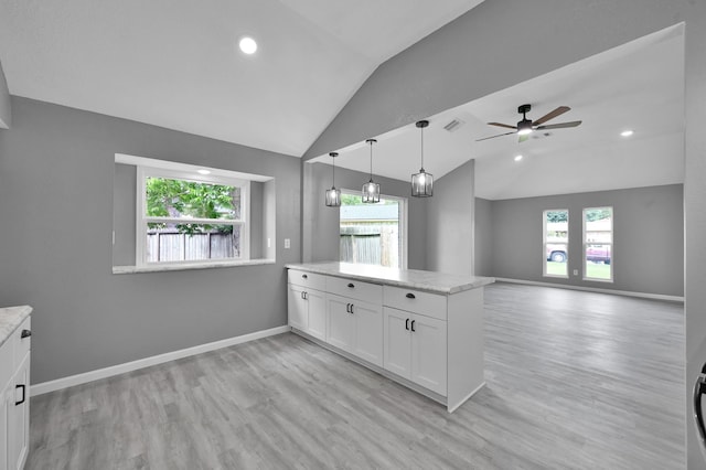 22603 Pebworth Pl, Spring, TX 77373 - kitchen featuring vaulted ceiling, white cabinetry, healthy amount of natural light, light wood-style flooring, and a peninsula