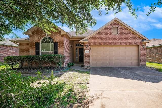ranch-style house featuring driveway, roof with shingles, brick siding, and a garage