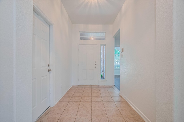 entrance foyer with light tile patterned floors and baseboards