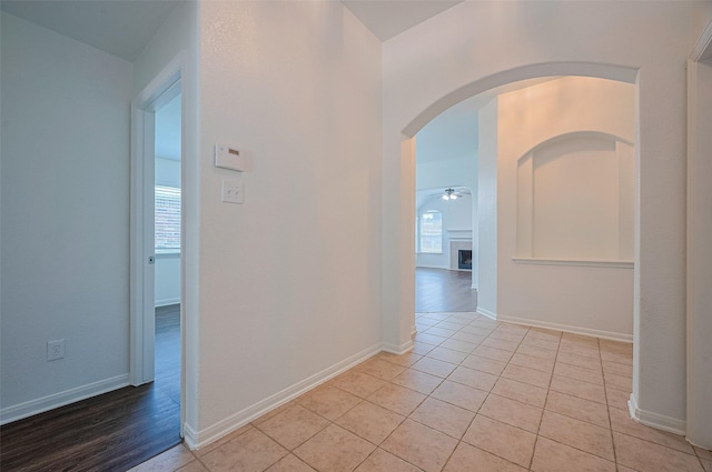 corridor featuring light tile patterned floors and baseboards