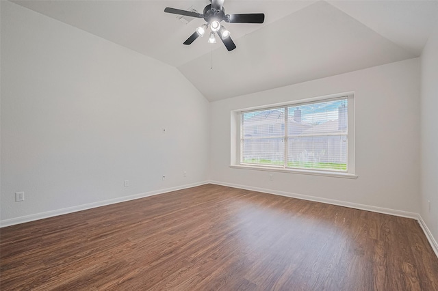 empty room featuring lofted ceiling, baseboards, dark wood finished floors, and ceiling fan