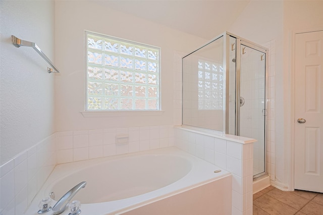 full bathroom featuring a garden tub, a wealth of natural light, and a shower stall