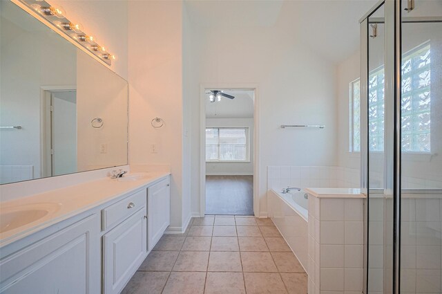 bathroom with double vanity, a garden tub, a sink, tile patterned floors, and ceiling fan