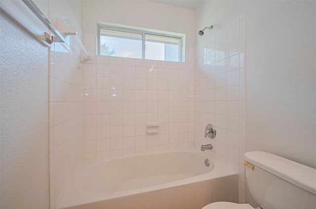 full bath with toilet, a textured wall, and bathtub / shower combination