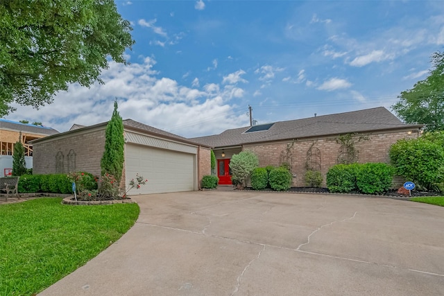 single story home featuring brick siding, roof with shingles, and a front yard