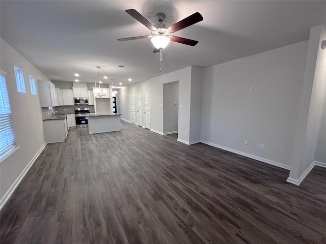813 Apple Blossom Dr, La Marque, TX 77568 - unfurnished living room featuring dark wood-type flooring, baseboards, a ceiling fan, and recessed lighting