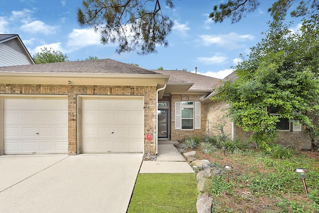 7551 Basswood Forest Ct, Houston, TX 77095 - view of front of property with an attached garage, concrete driveway, a shingled roof, and brick siding