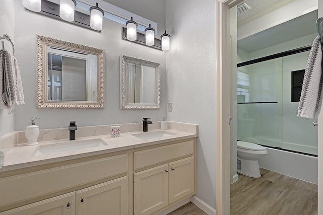 7551 Basswood Forest Ct, Houston, TX 77095 - bathroom with wood finished floors, toilet, double vanity, and enclosed tub / shower combo