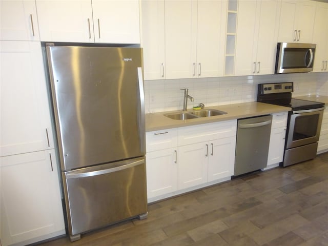 2401 Crawford Unit 105, Houston, TX 77004 - kitchen featuring appliances with stainless steel finishes, a sink, tasteful backsplash, and white cabinetry