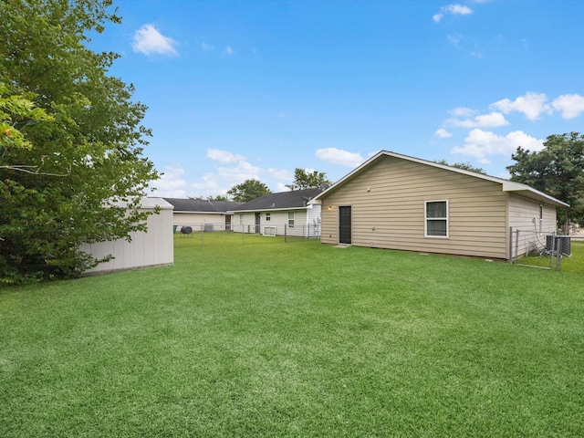 rear view of property with a lawn, a fenced backyard, an outdoor structure, and a storage shed