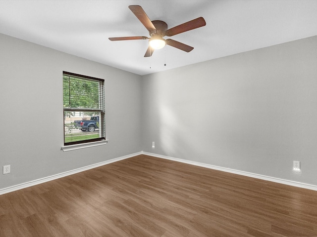 unfurnished room featuring wood finished floors, baseboards, and ceiling fan