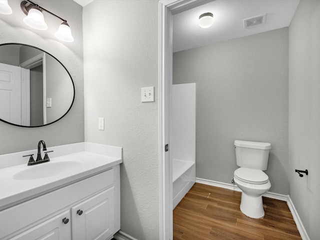bathroom with toilet, wood finished floors, visible vents, baseboards, and vanity