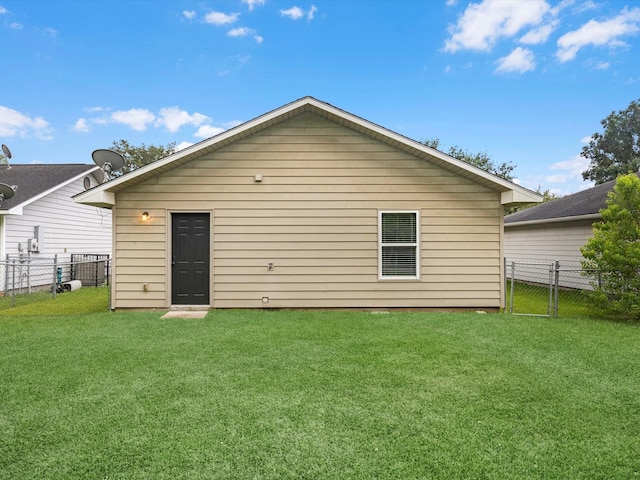 back of property with a lawn and fence