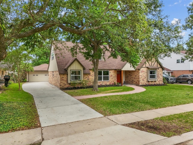 english style home featuring a garage, a shingled roof, board and batten siding, a front yard, and brick siding