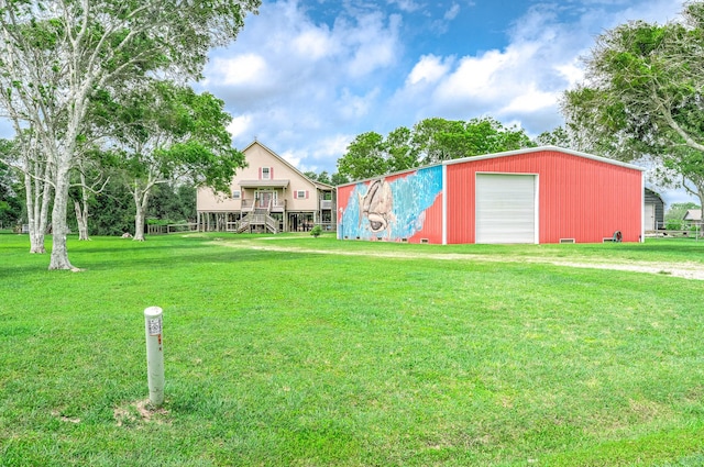 view of yard with a detached garage, an outbuilding, and driveway