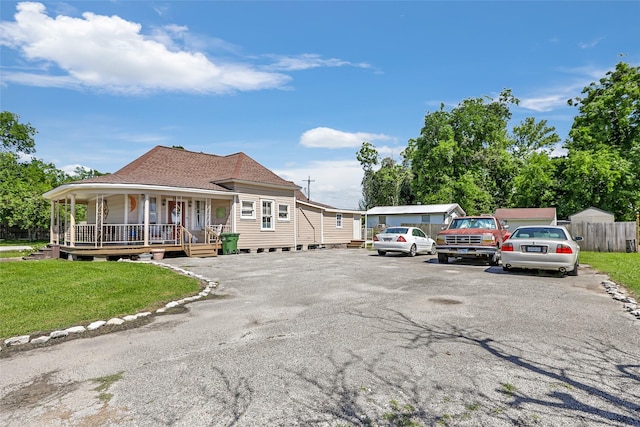 311 Depot St, Dayton, TX 77535 - view of front facade with a porch, a shingled roof, a front lawn, and fence
