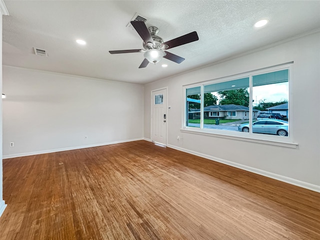 unfurnished room with baseboards, visible vents, wood finished floors, and a ceiling fan