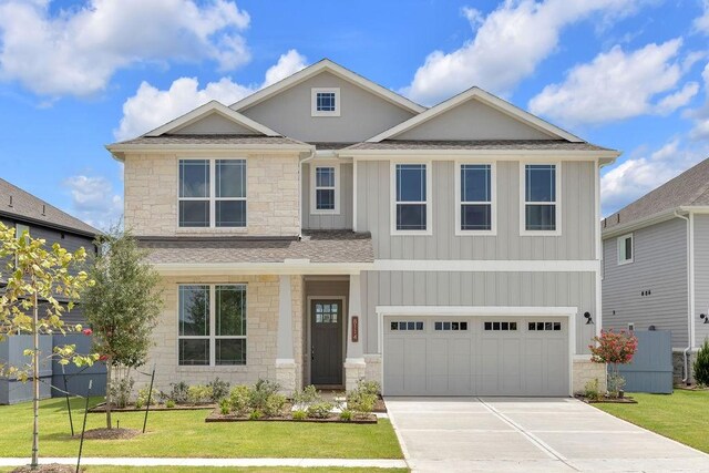8114 Red Shiner Way, Fulshear, TX 77441 - view of front of house featuring stone siding, board and batten siding, driveway, and a front yard