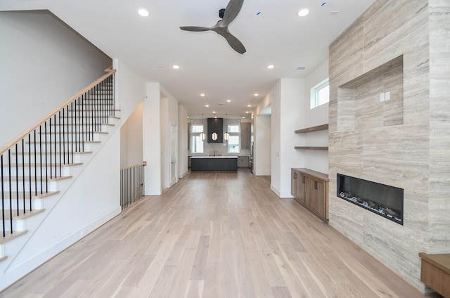 4709 Gibson St, Houston, TX 77007 - unfurnished living room featuring a ceiling fan, light wood-style floors, recessed lighting, stairway, and a tile fireplace