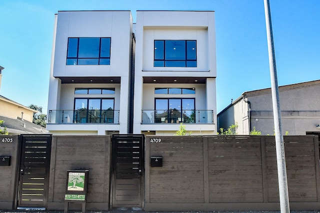 4709 Gibson St, Houston, TX 77007 - view of front of home with a fenced front yard, stucco siding, and a balcony
