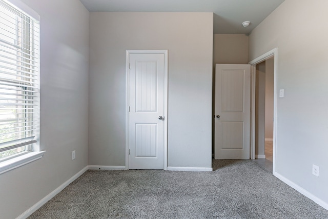 1219 Governor Dr, Richmond, TX 77469 - unfurnished bedroom with multiple windows, carpet, and baseboards
