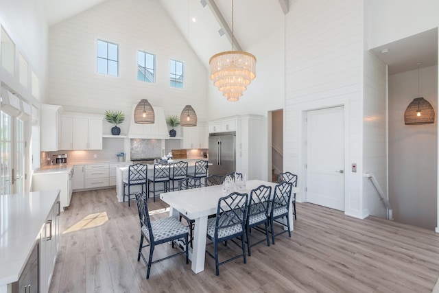 201 Lakeshore St, Port Aransas, TX 78373 - dining area with light wood-type flooring, an inviting chandelier, and high vaulted ceiling