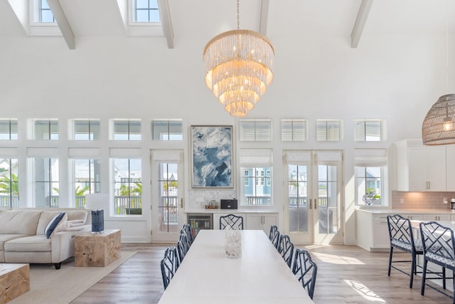 201 Lakeshore St, Port Aransas, TX 78373 - dining room featuring an inviting chandelier, french doors, light wood-style flooring, and high vaulted ceiling