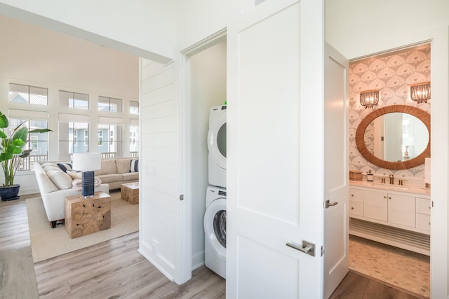 201 Lakeshore St, Port Aransas, TX 78373 - laundry room featuring stacked washer / dryer, laundry area, a sink, and light wood-style floors