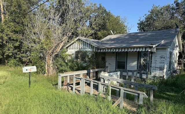 rear view of property featuring a shingled roof