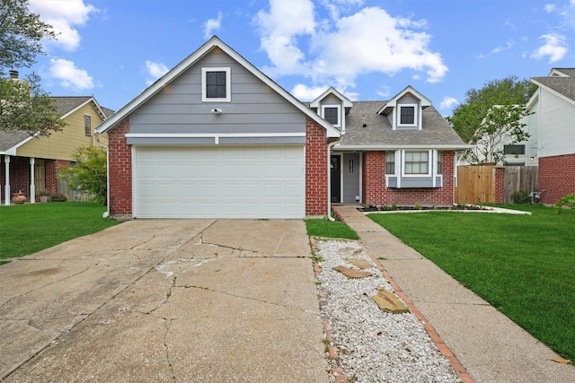view of front of house with driveway, brick siding, a front yard, and fence