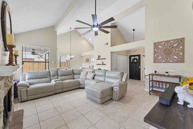 living area with light tile patterned floors, ceiling fan with notable chandelier, high vaulted ceiling, visible vents, and baseboards