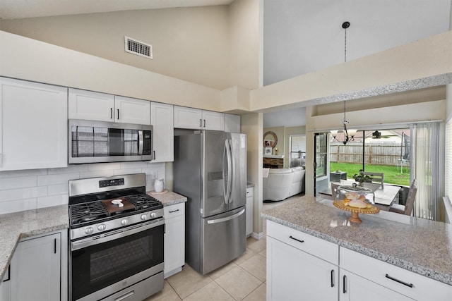 kitchen featuring tasteful backsplash, visible vents, high vaulted ceiling, stainless steel appliances, and white cabinets